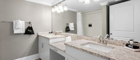 A bathroom with two sinks, a large mirror, and a towel rack.