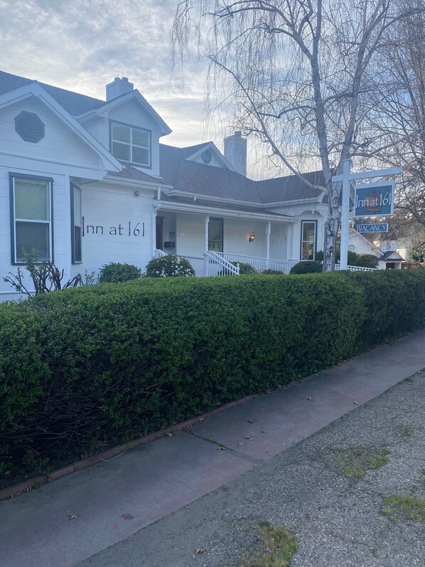 A two-story white building with a sign reading "Inn at 161" and a "VACANCY" sign.