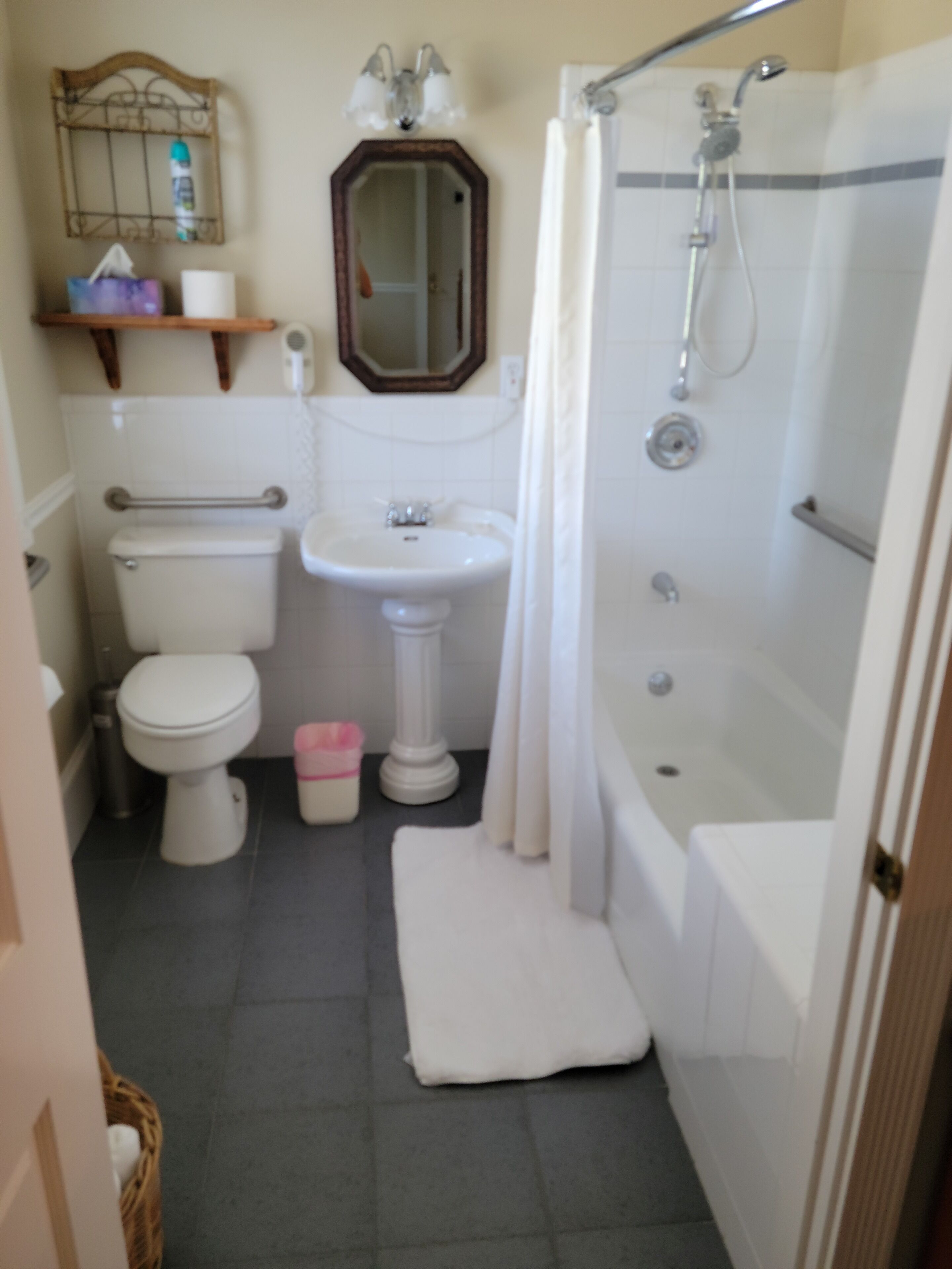 A bathroom with a toilet, sink, and shower.
