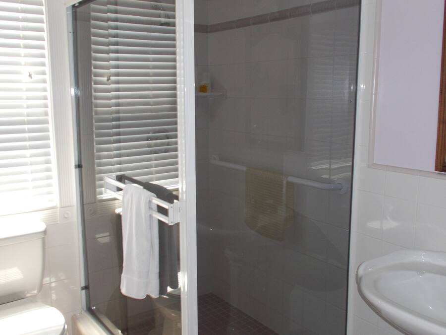 Ein Badezimmer mit einer Duschkabine, einer Toilette und einem Waschbecken.