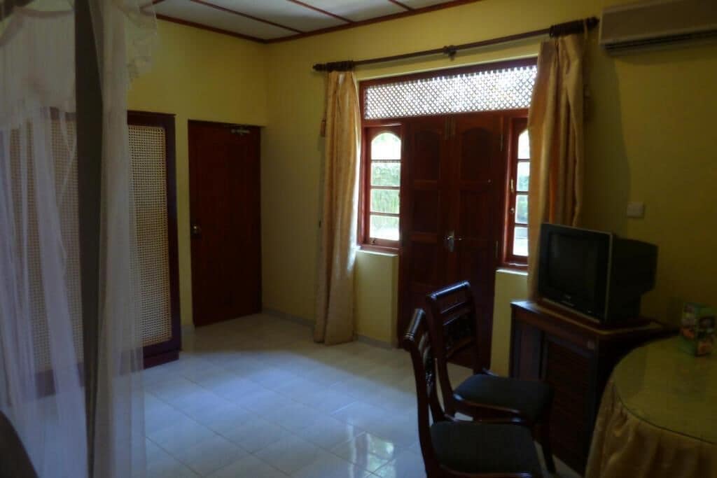 Una habitación con una cama, televisión y una mesa.