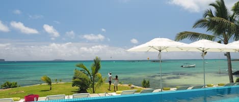 Piscine extérieure, parasols de plage, chaises longues