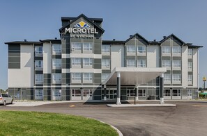 A Microtel by Wyndham hotel with a modern design, featuring a covered entrance and multiple floors. - Microtel by Wyndham Casselman (Casselman)