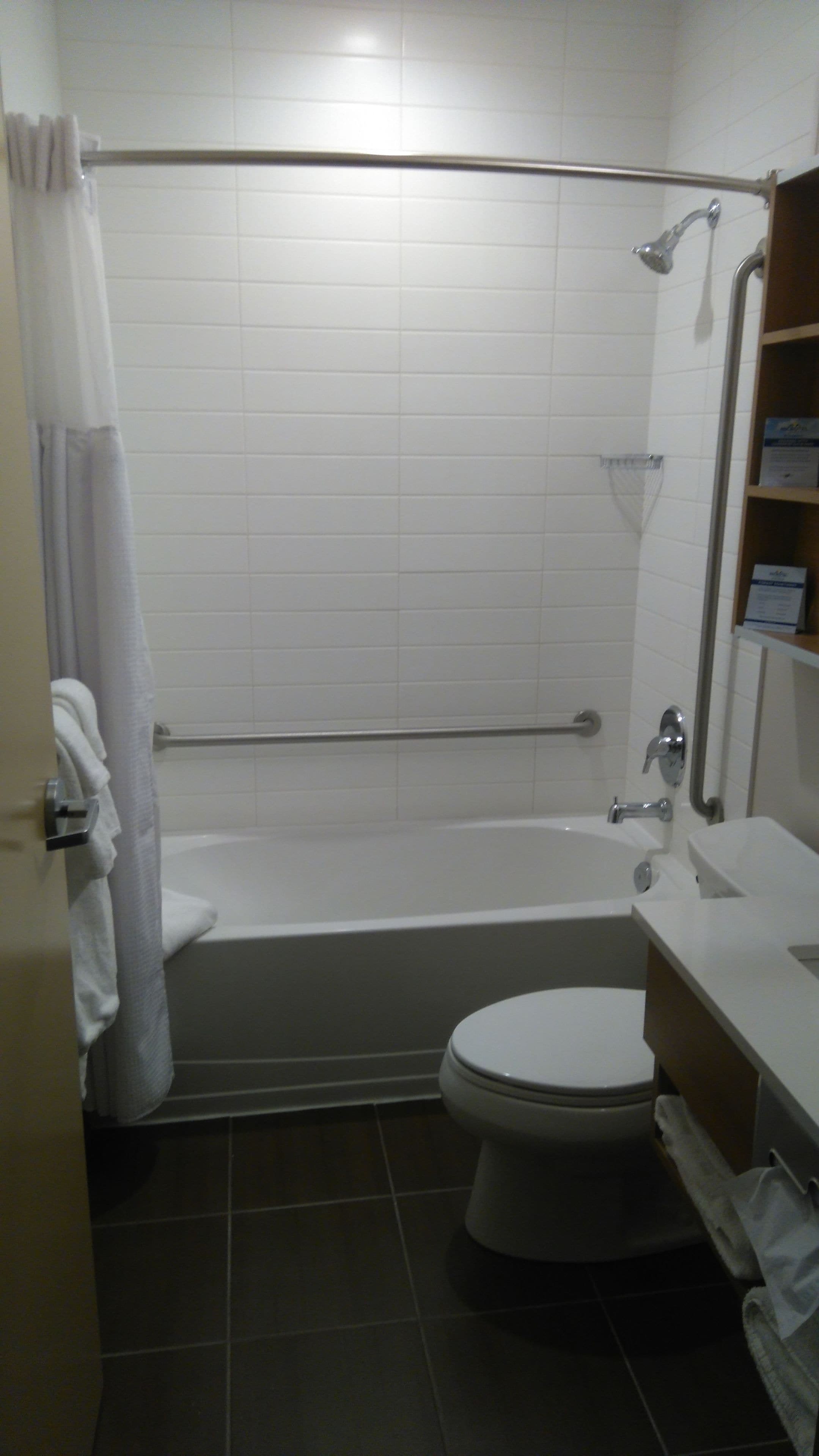 A bathroom with a bathtub, toilet, and a shower area.