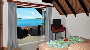 Une chambre avec un lit, une télévision et une vue sur la mer.