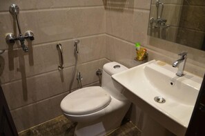 Une salle de bain avec des toilettes, un lavabo et une douche.