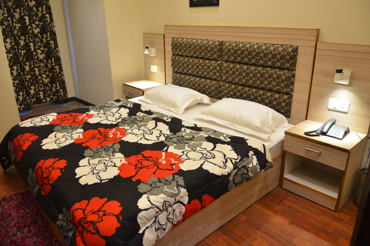 A hotel room with a bed, nightstands, and a telephone.