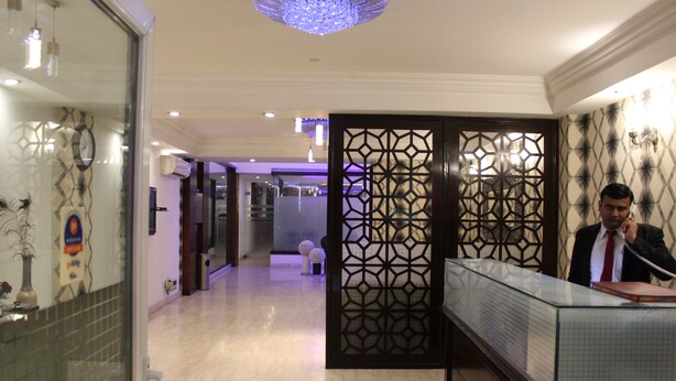 Ein Hotel-Empfangsbereich mit Glastisch, einer Zierverkleidung und einem modernen Innenarchitekturstil.