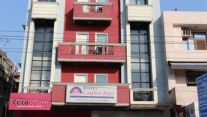 Ein mehrstöckiges Gebäude mit einem Schild für "Hotel Comfort Zone" und einem Geschäft für "Cocoberry Premium Frozen Yogurt".