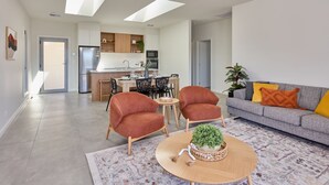 A modern living room with a grey sofa, red armchairs, and a coffee table with a plant. - BIG4 Launceston Holiday Park (South Launceston)