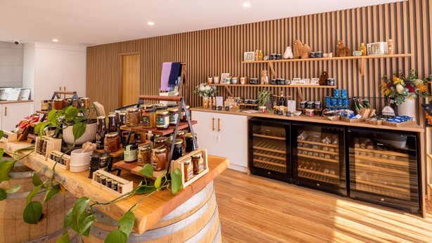 Un interior rústico con barriles de madera, estantes con frascos y una variedad de objetos a la vista.