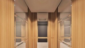 A modern closet with wooden panels and multiple shelves. - Cipta Hotel Pancoran (Jakarta)