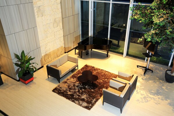 A modern living room with a piano, sofas, and a coffee table.