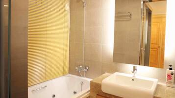 Un baño moderno con bañera, ducha y lavamanos.