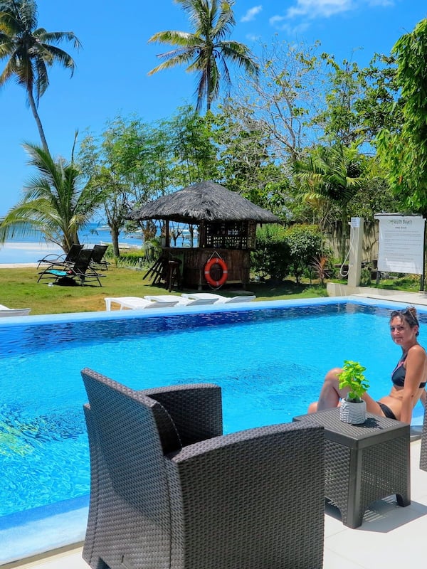 Una piscina al aire libre, sombrillas, tumbonas