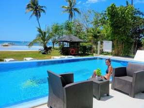 Una piscina al aire libre, sombrillas, sillones reclinables de piscina