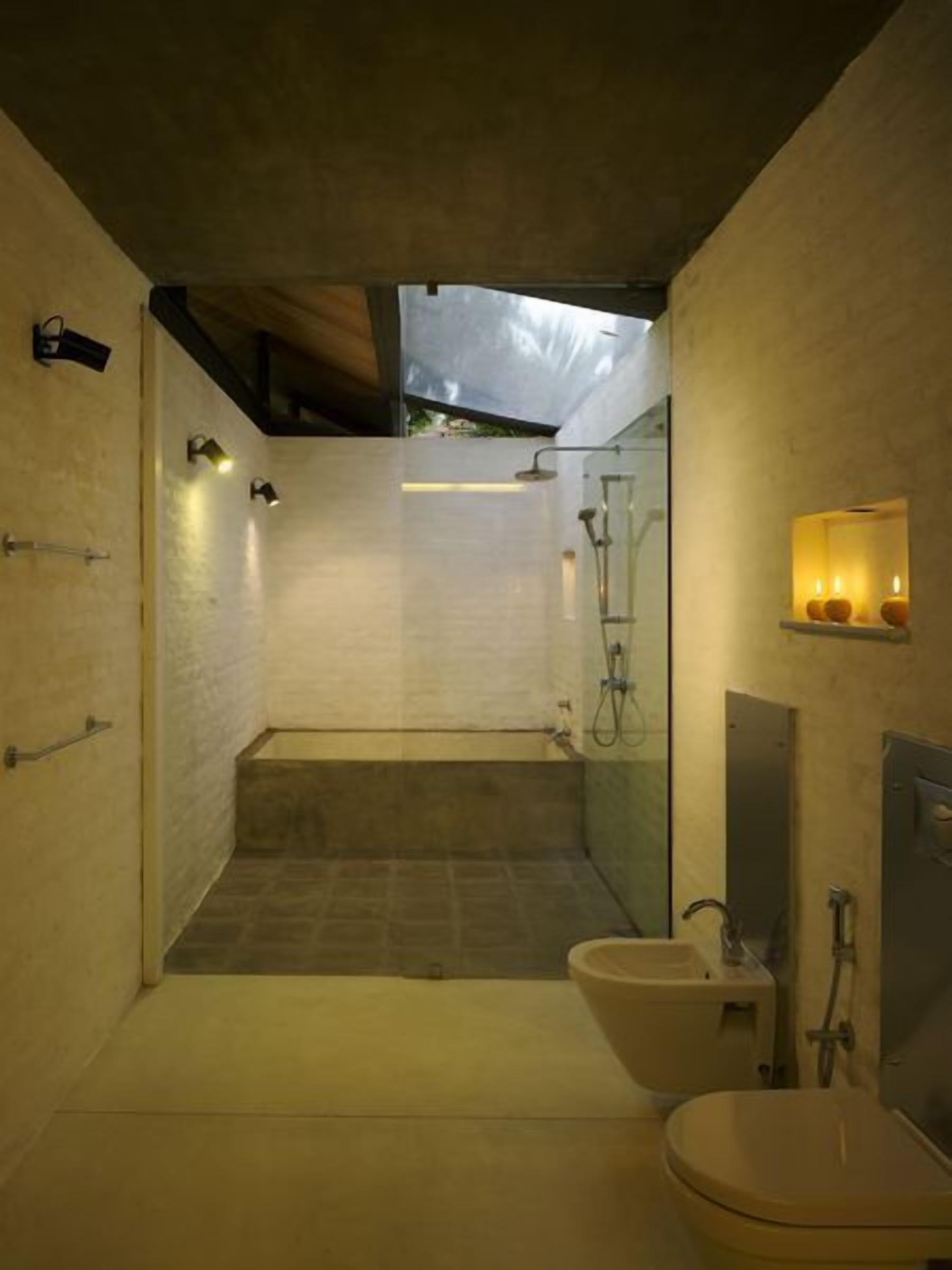 A modern bathroom with a shower, toilet, and sink.