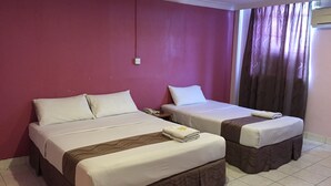 Una habitación de hotel con dos camas, un teléfono en la mesita de noche y una ventana con cortinas.
