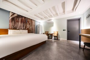 A modern hotel room with a large bed, a desk, a chair, and a small table. - Hotel New Evergreen (Mokpo)