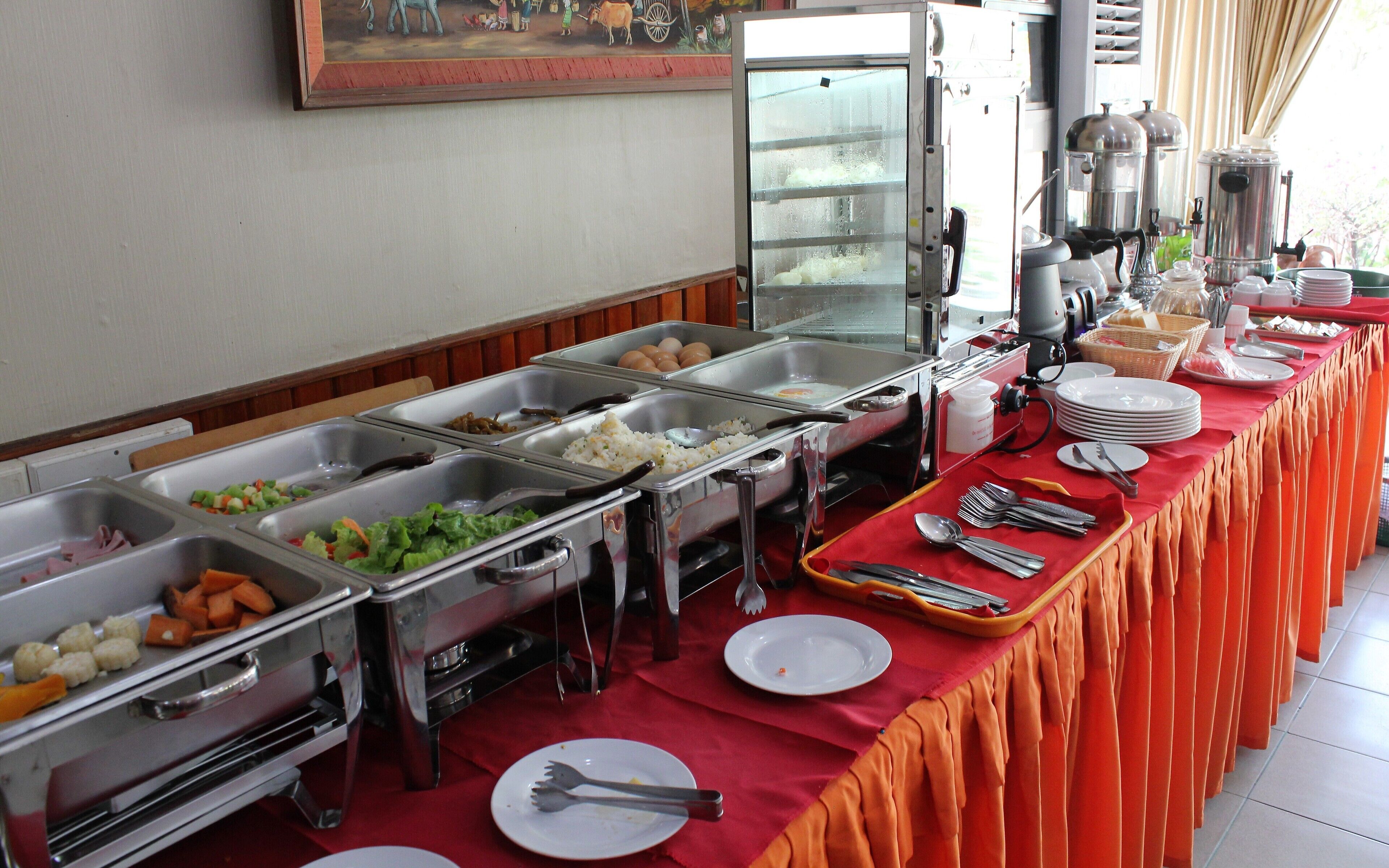 A buffet setup with various food items and utensils.