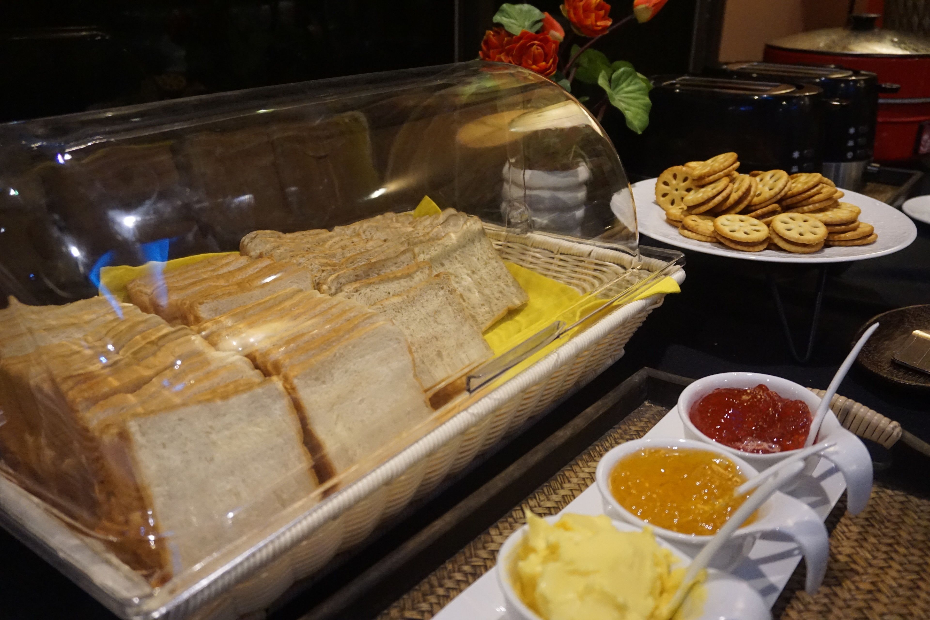 Un bufé con sándwiches, galletas y dos tipos de untables.