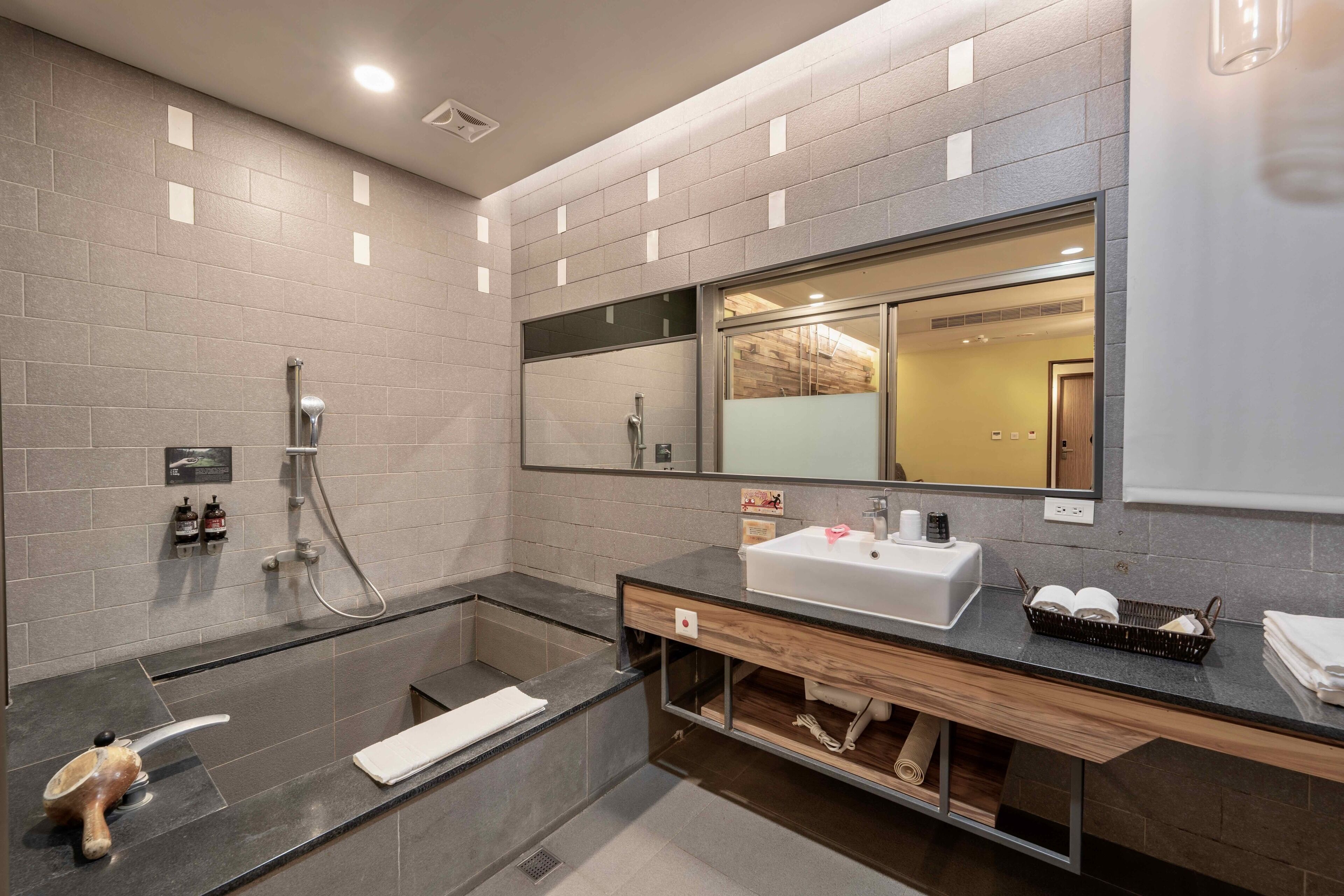 Une salle de bain moderne avec une baignoire, un lavabo et un grand miroir.