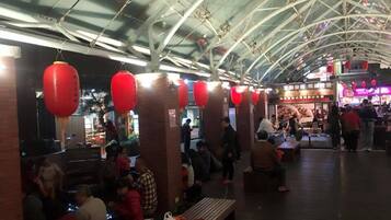 Un mercado interior con un techo alto en arco y faroles rojos.