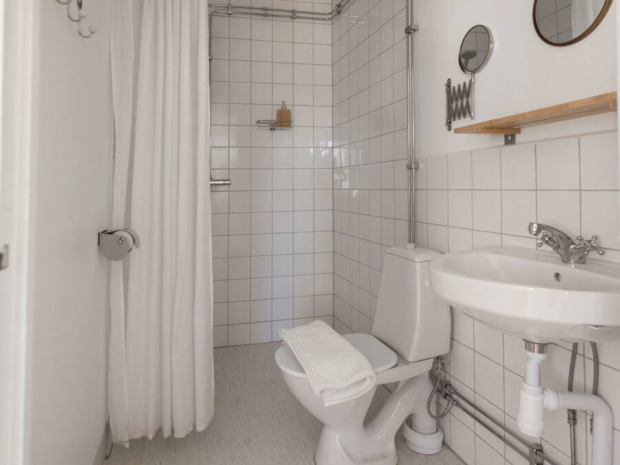 A bathroom with a toilet, sink, and shower.