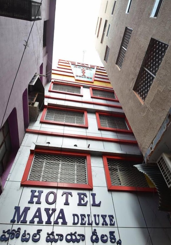 A multi-story building with a sign reading "HOTEL MAYA DELUXE".
