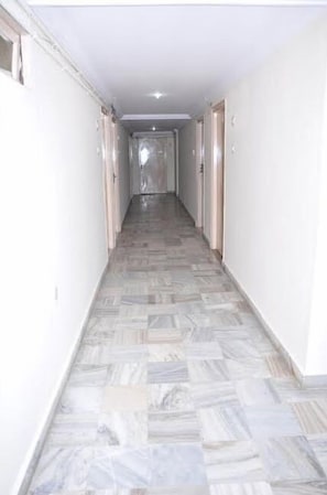 A hallway with patterned flooring and white walls.