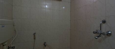 Um banheiro pequeno com azulejos, vaso sanitário, chuveiro e uma janela sobre o vaso.