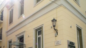 Un bâtiment sur lequel on peut lire les enseignes « Hôtel KERDOUS » et « Hôtel KOZOPOS ». Des plantes en pot sont disposées devant le bâtiment.