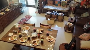 Un comedor con una gran mesa de madera dispuesta para una comida, rodeada de sillas.