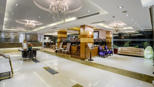 A spacious lobby with a reception desk, seating area, and chandeliers. - Hotel Bengal Blueberry (Dhaka)