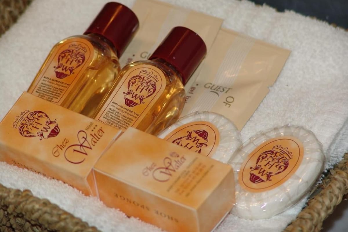 A set of toiletries including bottles of lotion and soap, arranged on a white towel.