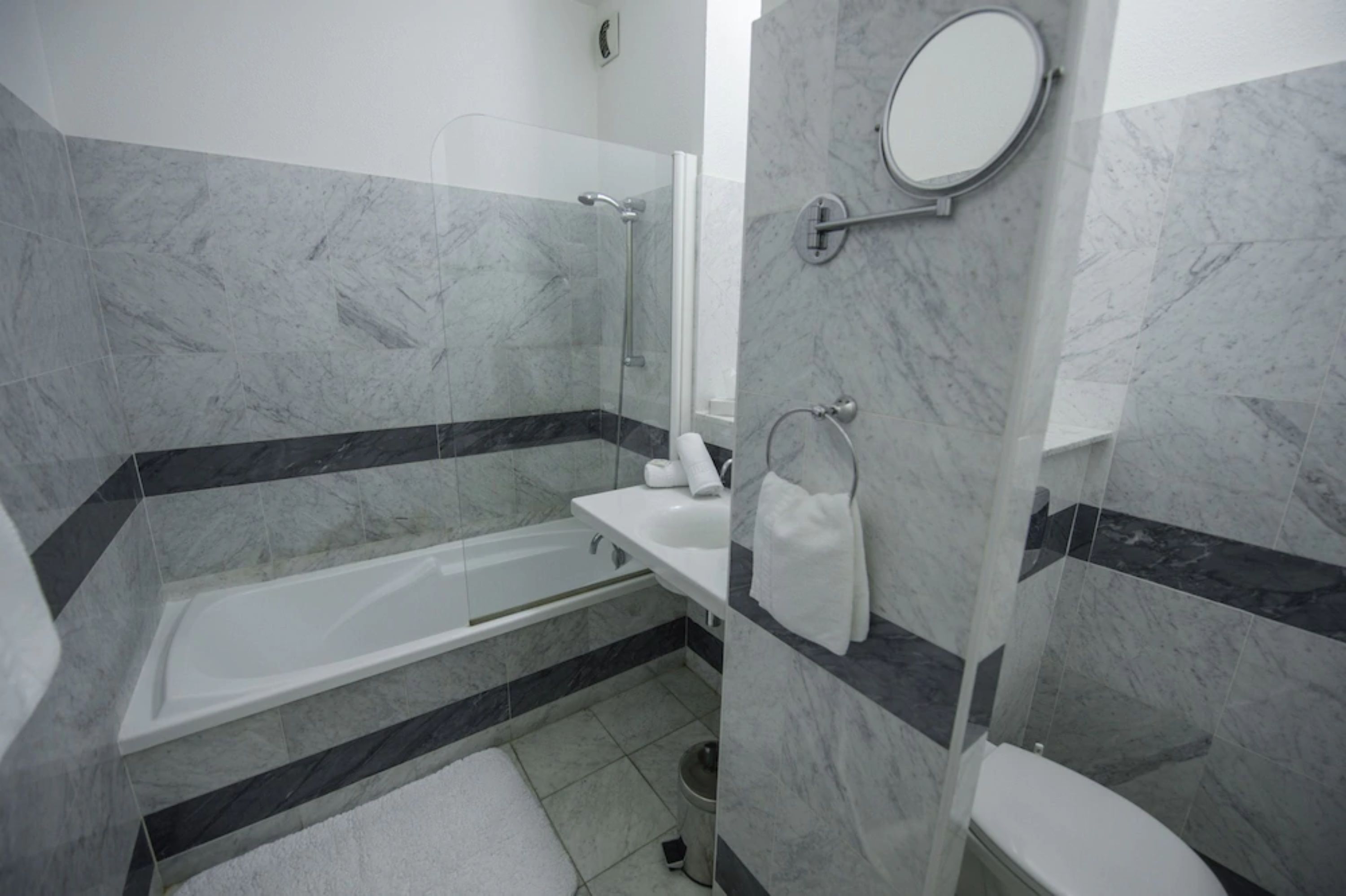 A modern bathroom with a bathtub, a toilet, and a shower area.