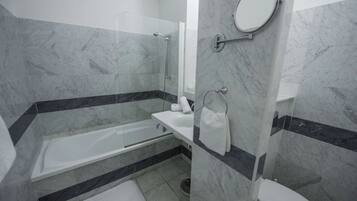 A modern bathroom with a bathtub, a toilet, and a shower area.
