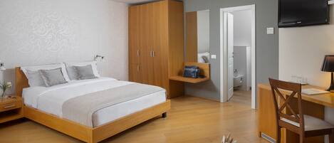 Un dormitorio moderno con una cama de madera, un escritorio, una silla y un televisor.