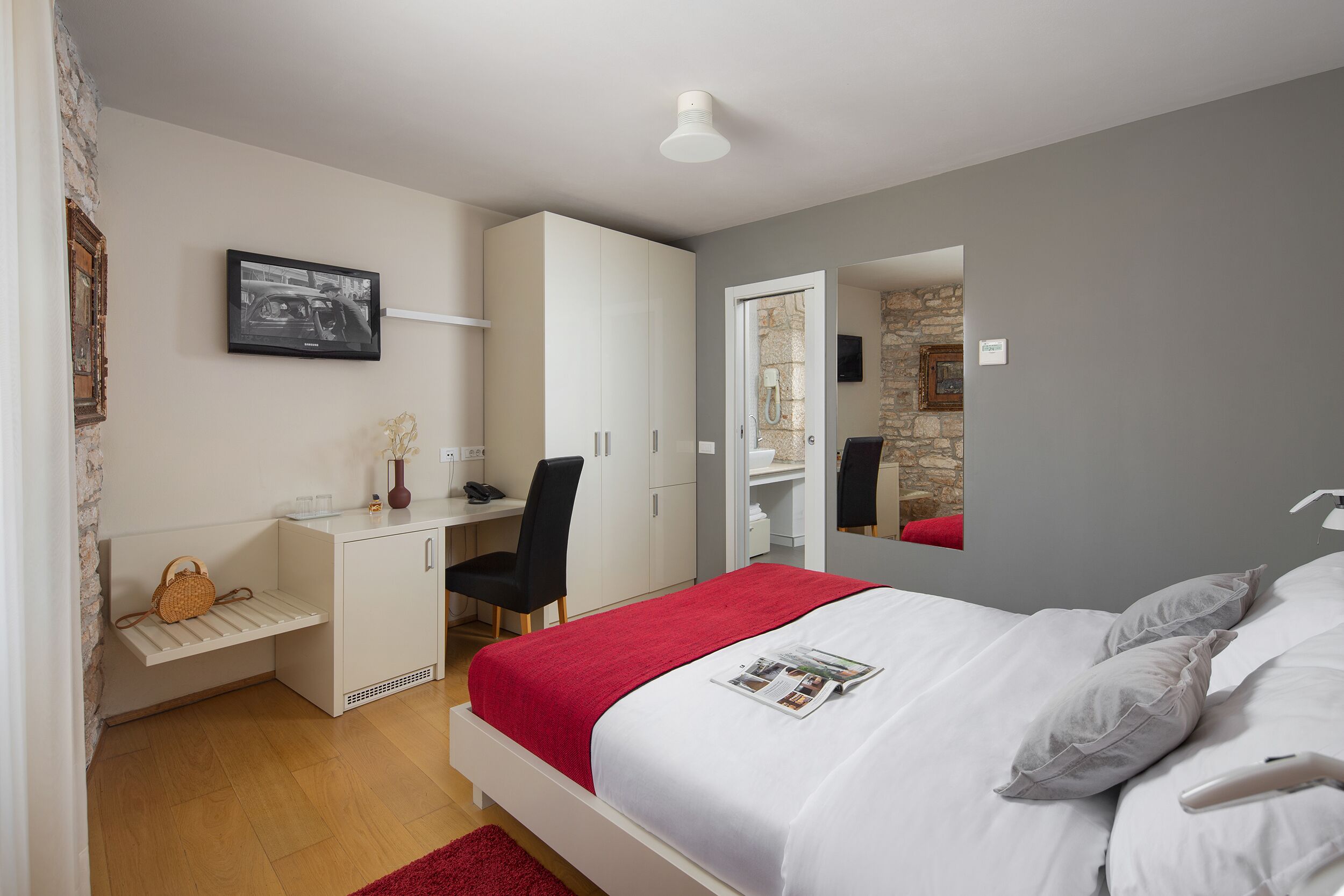 A bedroom with a bed, a desk, a chair, and a wardrobe.