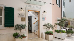 The entrance of Hotel La Grisa with a clear sign, a staircase, and potted plants. - Hotel La Grisa (Bale)