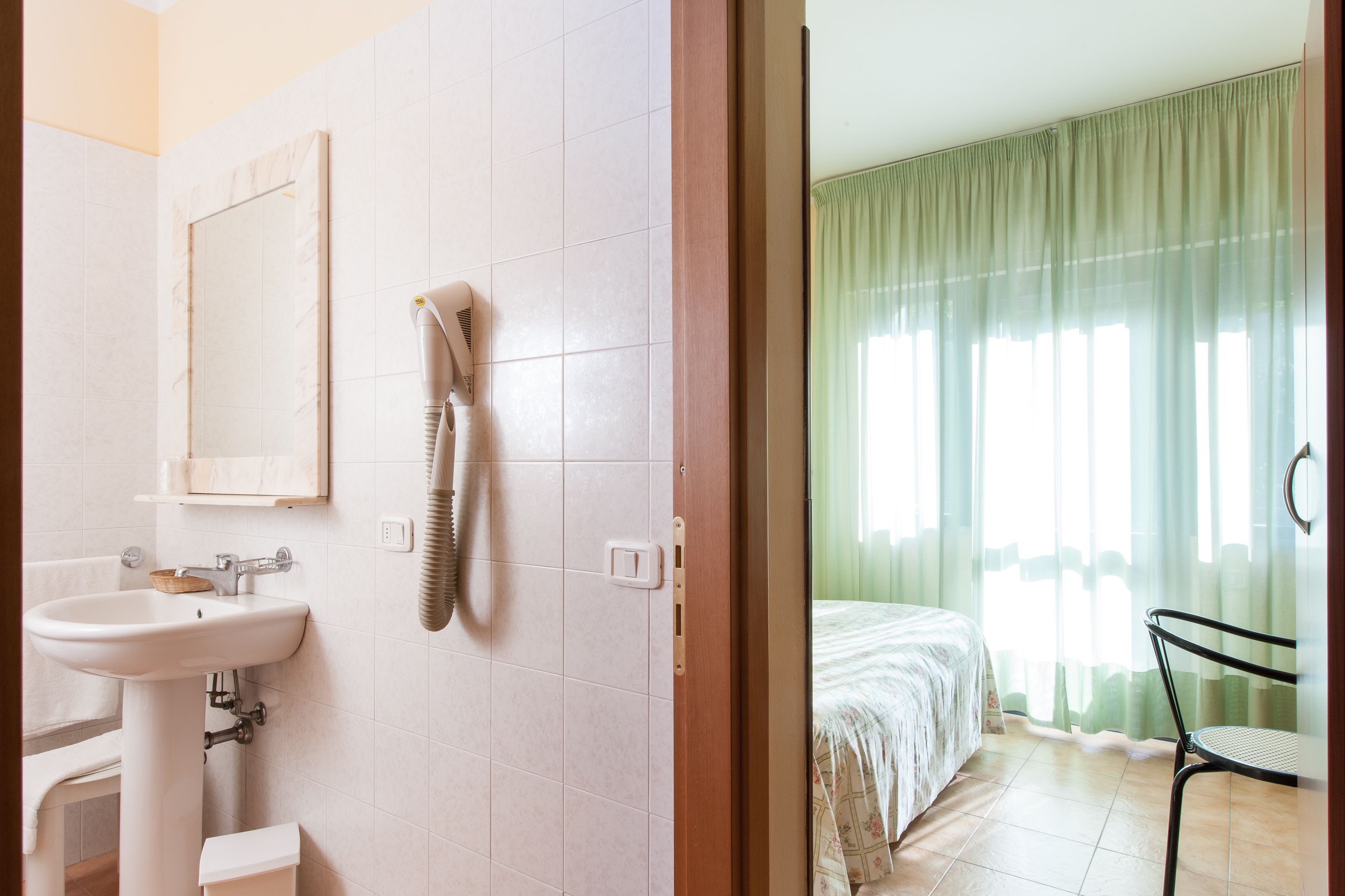 A bathroom with a sink, mirror, and towel rack.