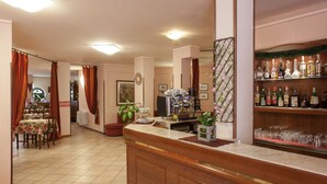A bar area with a counter, shelves with bottles, and a dining area with tables and chairs.