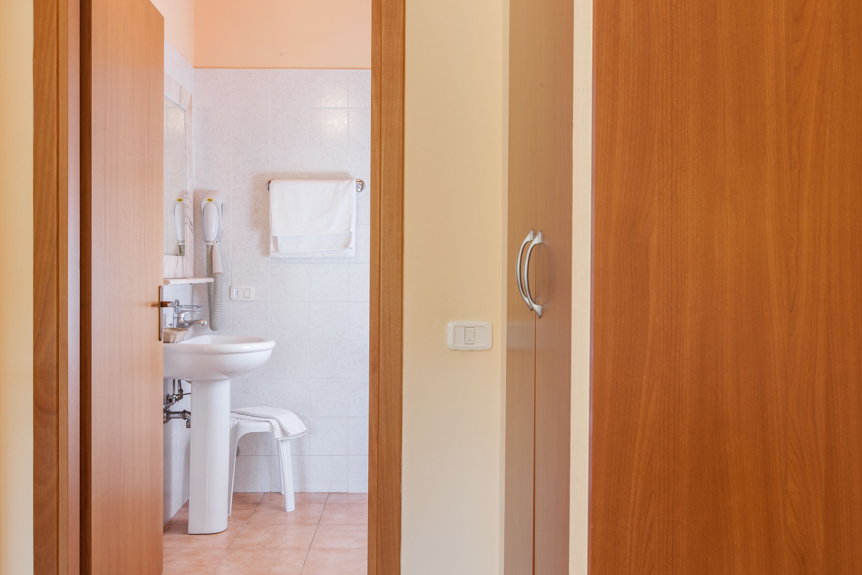 A bathroom with a white sink, toilet, and towel rack.