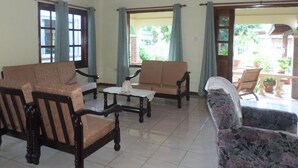 Un amplio salón con un conjunto de sofás, una mesa de centro y un sillón estampado.