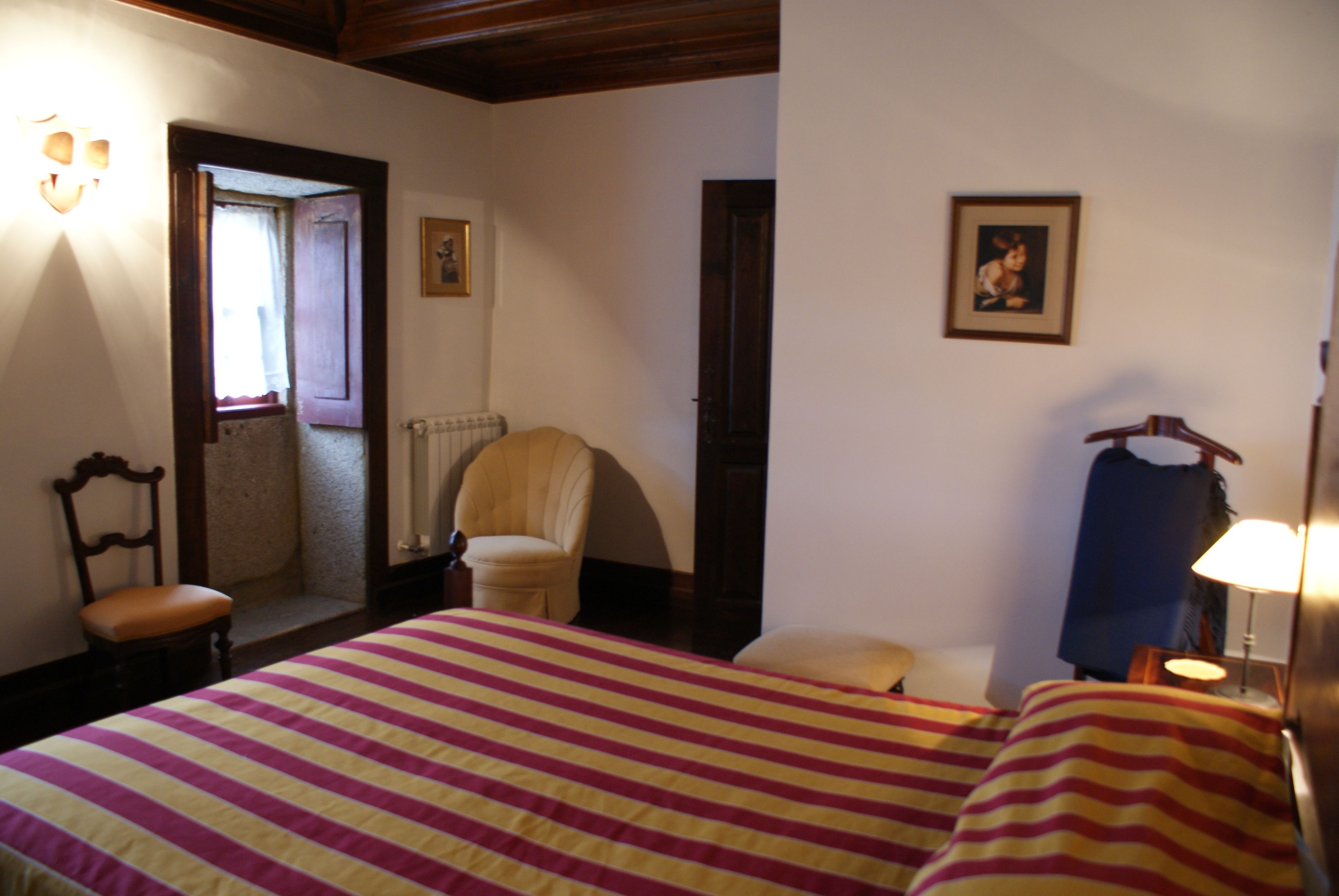 Une chambre d’hôtel avec un grand lit, une chaise, un bureau et une lampe.