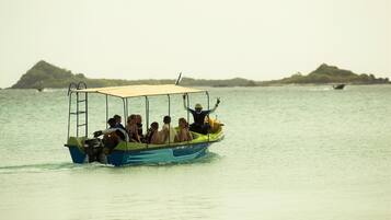 Un bote con pasajeros, una cubierta y una persona levantando la mano.