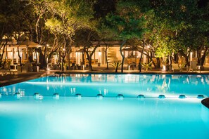 Una piscina al aire libre, tumbonas