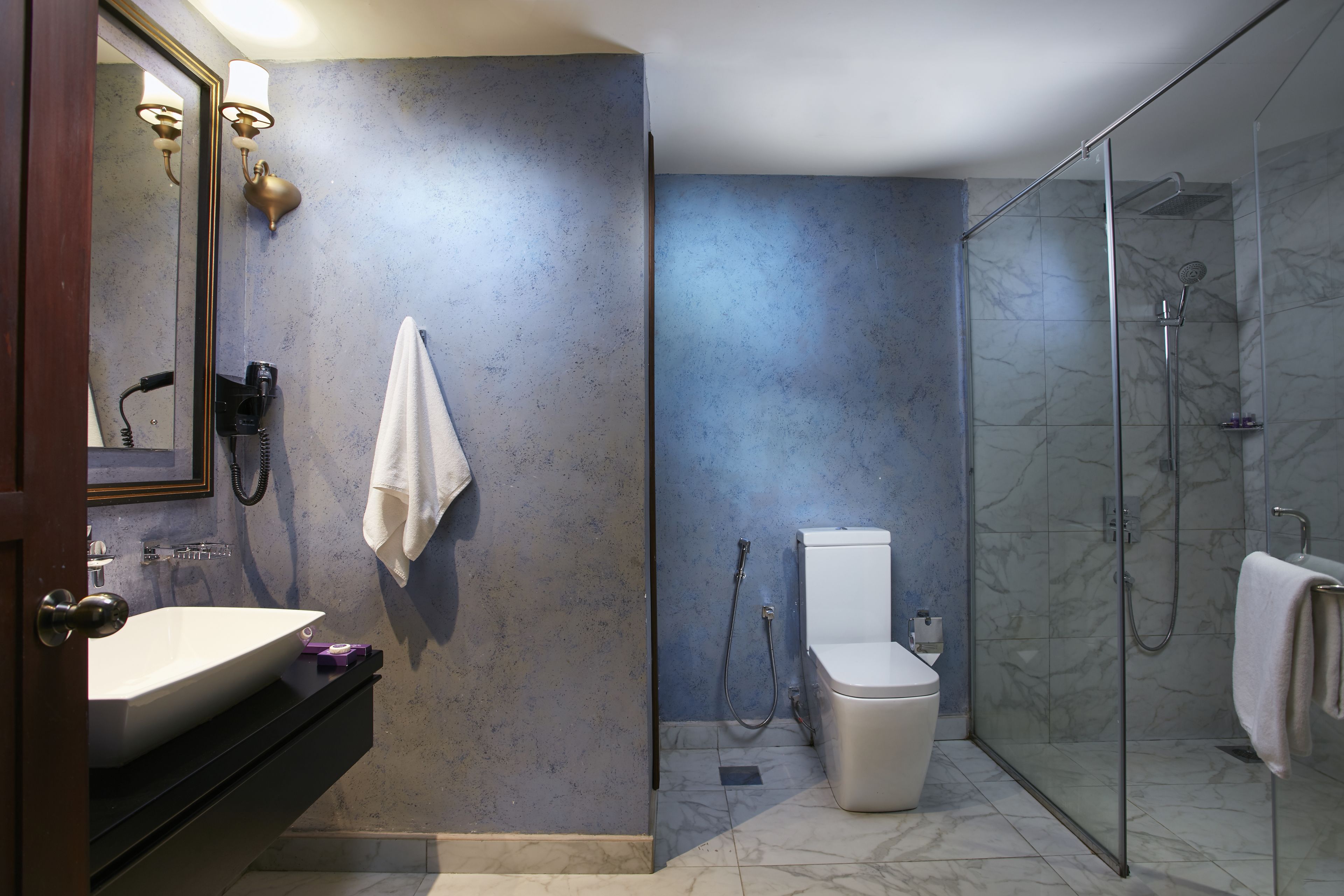 A bathroom with a white sink, a toilet, and a glass-enclosed shower.