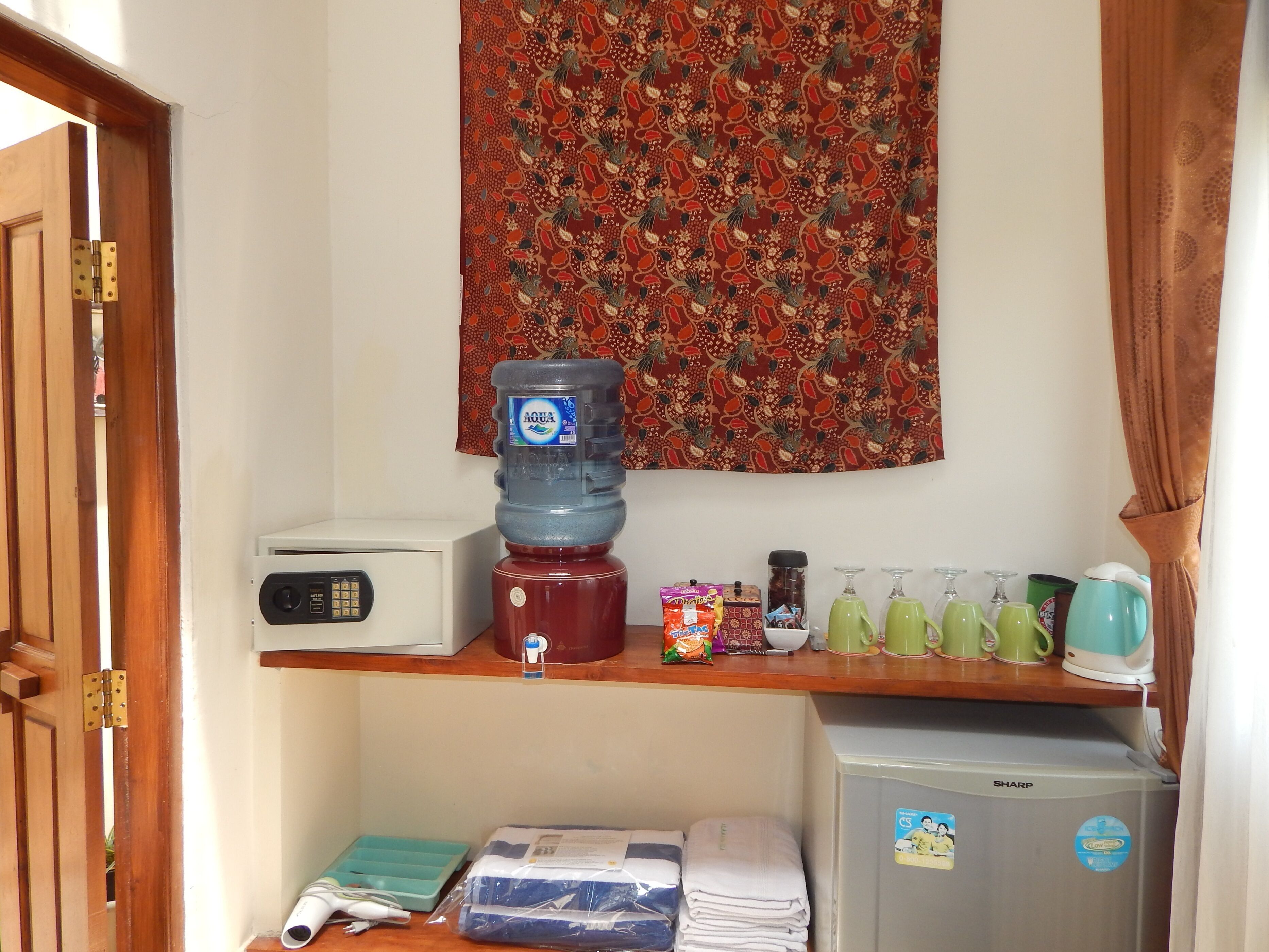 A kitchenette with a water dispenser, a toaster, a coffee maker, and a refrigerator.