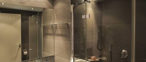 A modern bathroom with a glass-enclosed shower, a large mirror, and a wooden vanity with a sink.